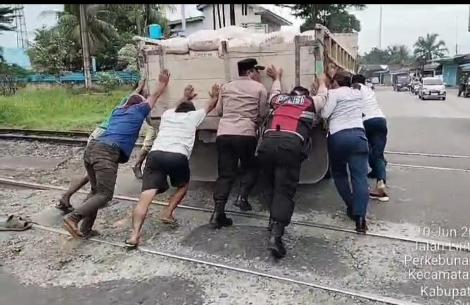 Personel Polsek Lima Puluh Evakuasi Truk Mogok di Atas Rel Kereta Api